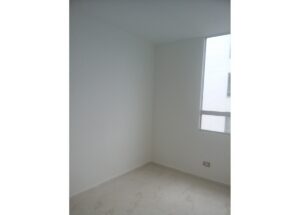 Empty, unfurnished white room with a window on the right and a light-colored floor.