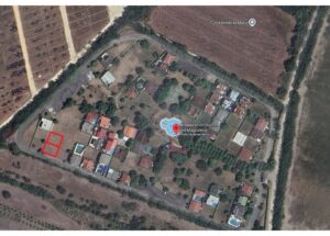 Aerial view of Urbanización Riveras del Magdalena with two neighboring lots outlined in red on the left side of the complex.